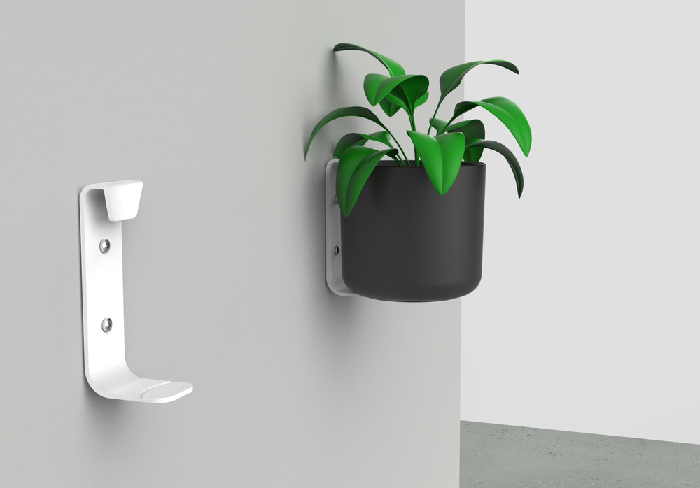 The pot hanging system installed on the wall with plants, showing the final product in use and how it enriches the living space.